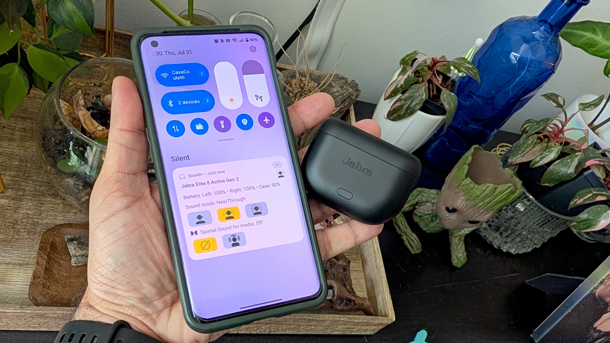 orang yang memegang earbud dan telepon dengan layar widget pintas