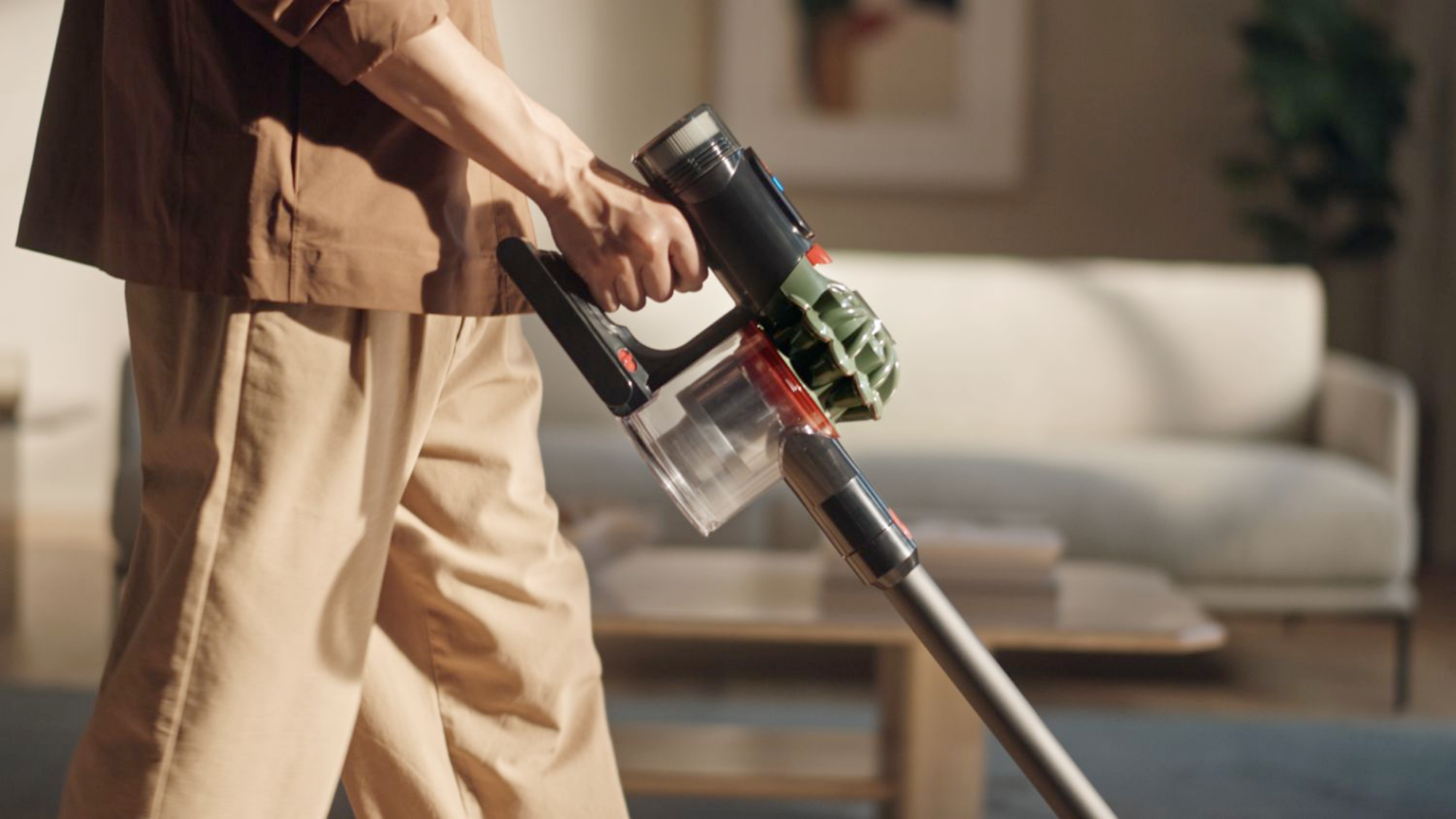 Seseorang yang menggunakan vakum tanpa kabel topan Dyson V8.