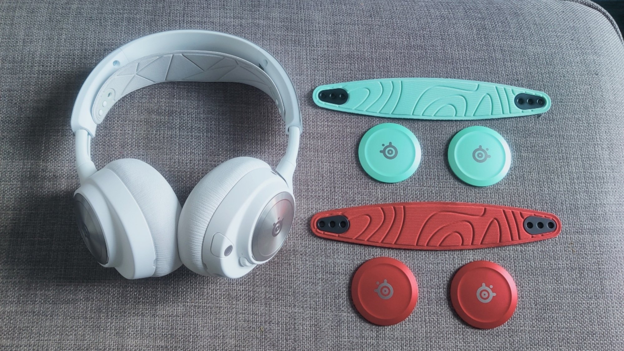 Steelseries Arctis Nova Pro Wireless In White dengan pelat speaker tambahan dan ikat kepala di Mint dan Red Cherry