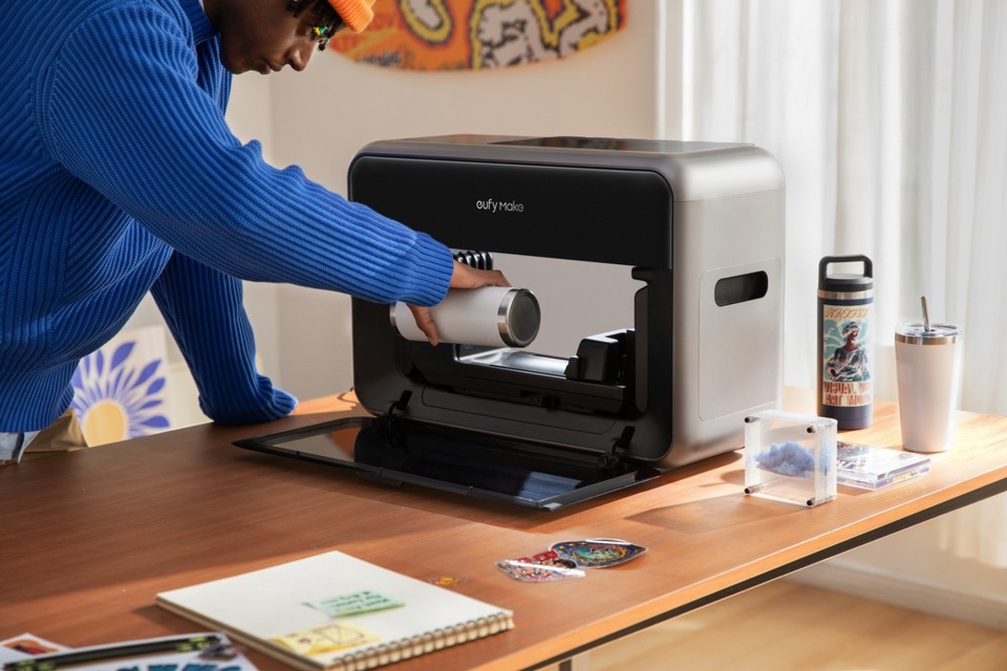 Seseorang menggunakan printer Eufymake E1 UV untuk membuat seni di rumah.