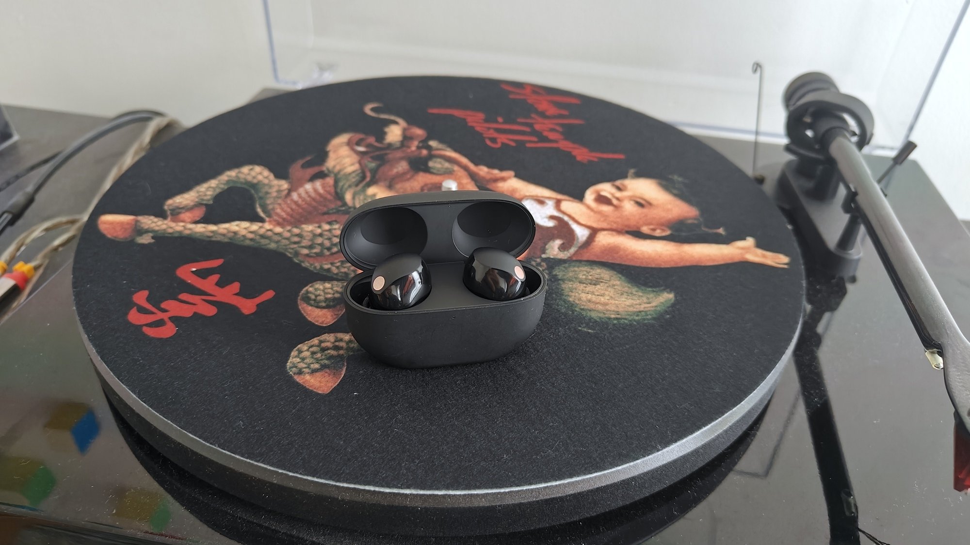 Sony Earbuds duduk di atas turntable pemain rekaman